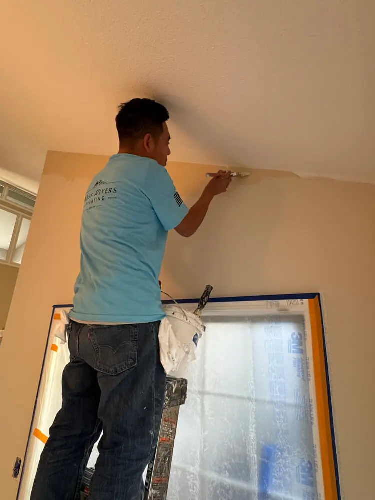 West Rivers Painting crew member cutting in ceiling line during interior painting project in Bend Oregon