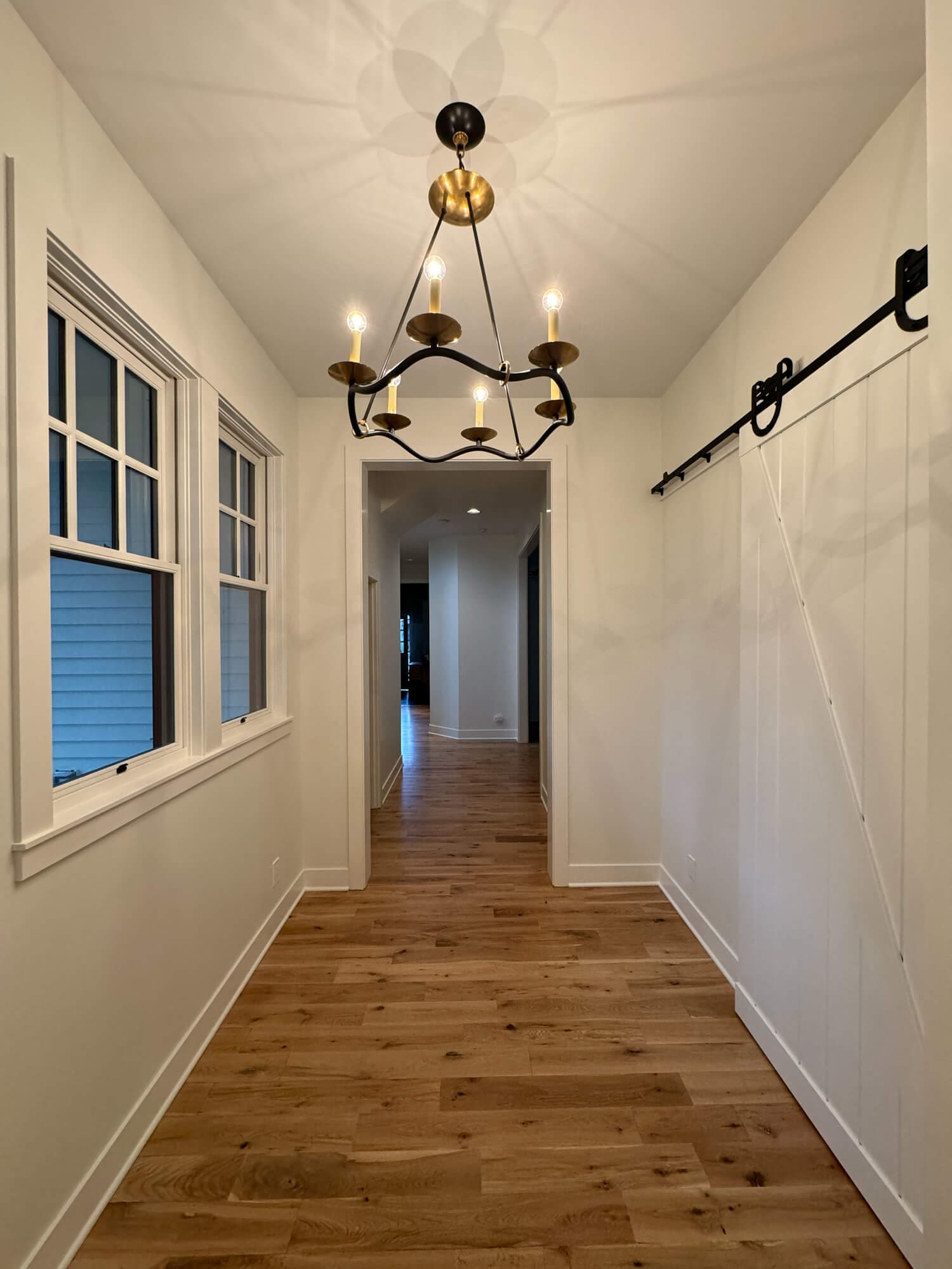 freshly painted white hallway with barn door and hardwood floors in Central Oregon home