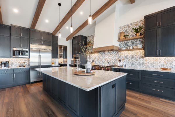 dark navy kitchen cabinets with marble island and exposed beam ceiling in Central Oregon home