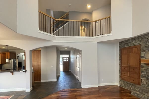 open concept living room with two-story ceiling and freshly painted gray walls in Bend Oregon home