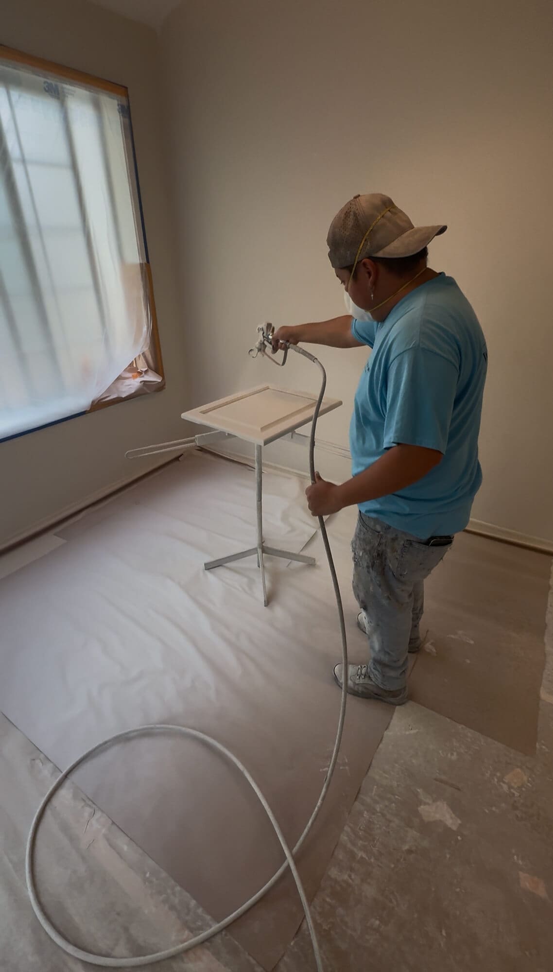 West Rivers Painting crew member spray painting cabinet door on-site during cabinet painting project in Bend Oregon