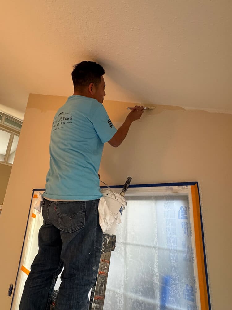 West Rivers Painting crew member cutting in ceiling line during interior painting project in Bend Oregon